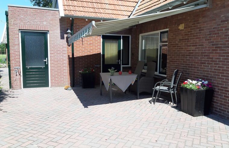 Geniet van de zonnige patio bij Huisje in Beuningen, een vakantiehuis in Twente, Overijssel, met comfortabele zitgelegenheid.