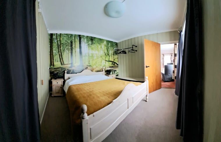 Gezellige slaapkamer in Huisje in Beuningen, vakantiehuis in Twente, Overijssel. Rustgevend bosbehang voor een natuurlijke sfeer.