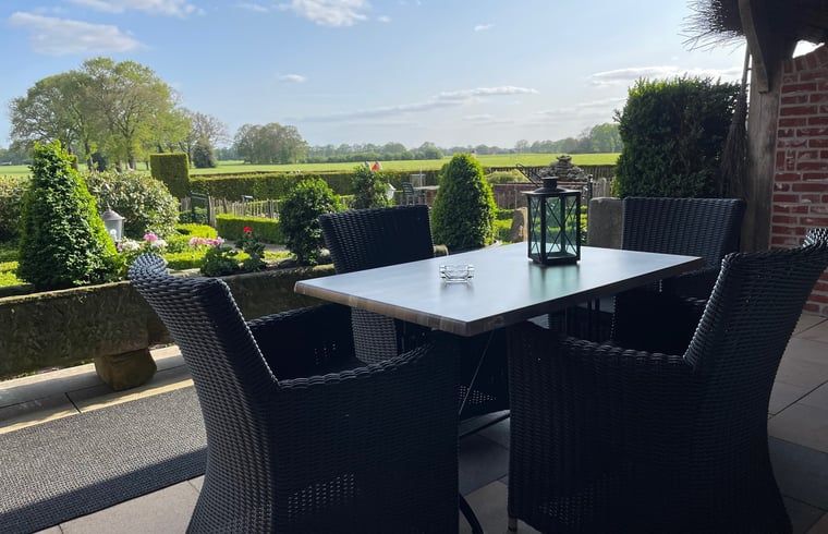 Terras met zitje bij Vakantiehuisje in Vasse, Twente, Overijssel, omgeven door natuur.