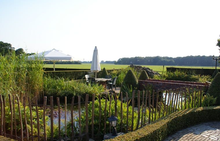 Rustige tuin met vijver bij Vakantiehuisje in Vasse, Twente, Overijssel.