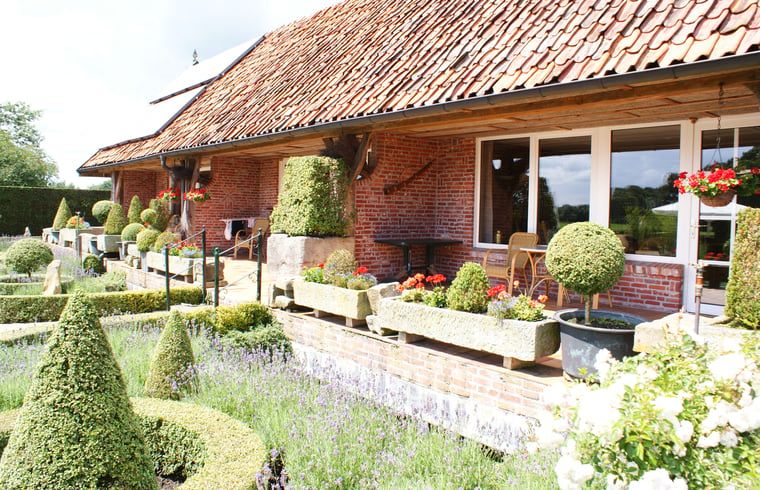 Charmante gevel van Vakantiehuisje in Vasse, Twente, Overijssel met bloementuin.