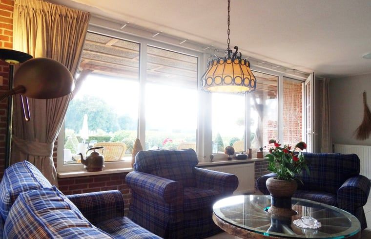 Gezellige woonkamer in Vakantiehuisje in Vasse, Twente, Overijssel met uitzicht op tuin.