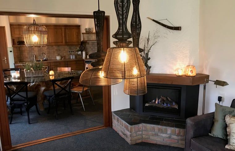 Esszimmer und Wohnzimmer in Cottage in Weerselo, Ferienhaus in Twente, Overijssel mit stimmungsvoller Beleuchtung.