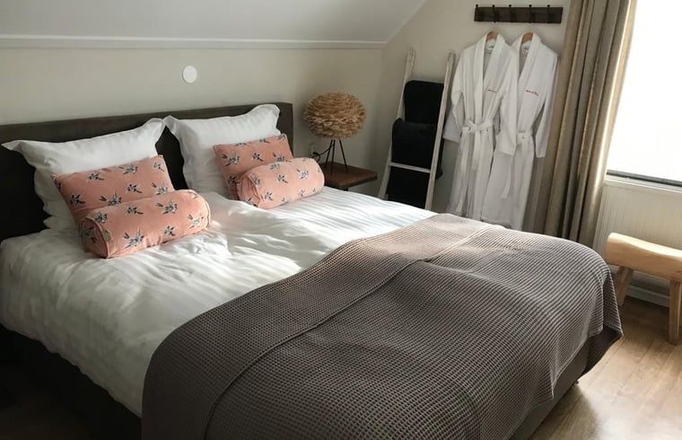 Gemuetliches Schlafzimmer in Cottage in Weerselo, Ferienhaus in Twente, Overijssel mit bunten Kissen.