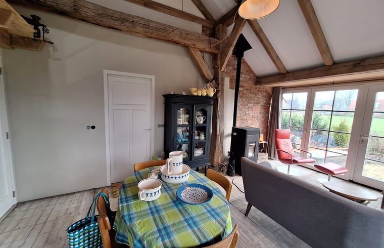 Gemuetlicher Innenraum des Ferienhauses in Tilligte, Twente. Authentische Holzdetails und stimmungsvolle Einrichtung in Overijssel.