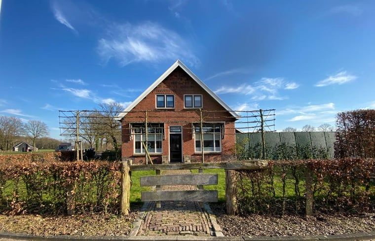 Buitenkant van Vakantiehuis in Reutum, Twente, Overijssel met traditionele architectuur en tuin.