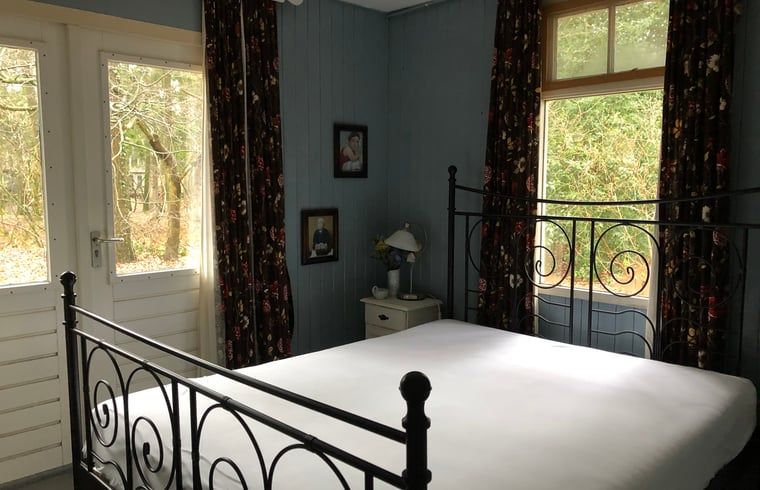 Attraktives Schlafzimmer im Huisje in Haaksbergen, einem Ferienhaus in Twente, Overijssel, mit Blick auf die umliegende Landschaft.