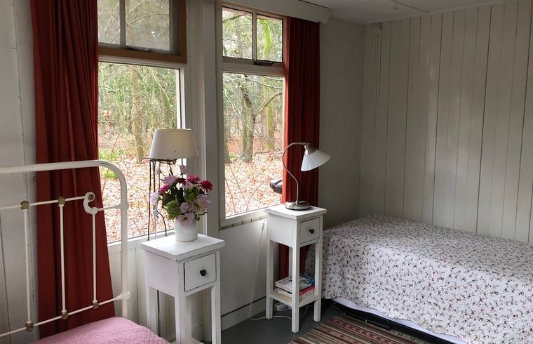 Gemuetliches Schlafzimmer in Cottage in Haaksbergen, Ferienhaus in Twente, Overijssel mit Blick auf ein Waldgebiet.