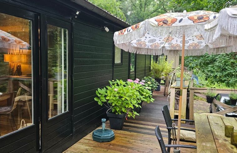 Gezellige veranda van Huisje in Haaksbergen, vakantiehuis in Twente, Overijssel, omringd door groene natuur en comfortabele zitgelegenheid.