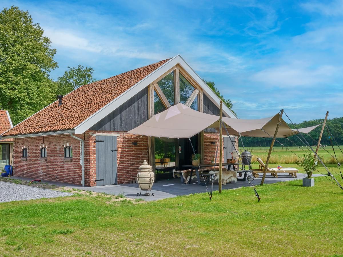The Green Getaway vakantiehuis in Haaksbergen, Twente met ruime veranda en uitzicht op groene velden.