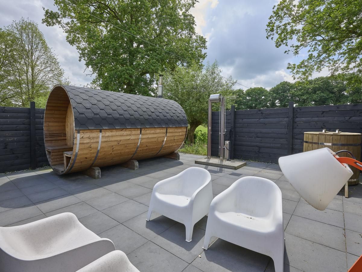 Zonnig terras bij The Green Getaway vakantiehuis in Haaksbergen, Twente met comfortabele ligstoelen.