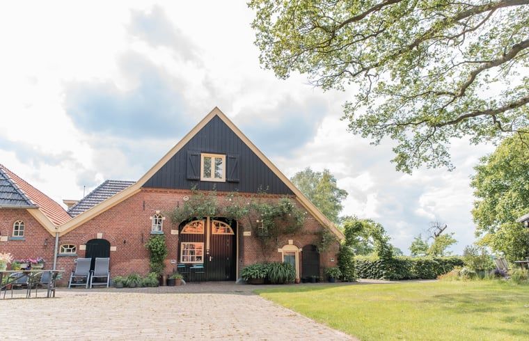 Charmant vakantiehuisje in Diepenheim, Twente met groene omgeving en traditionele architectuur.