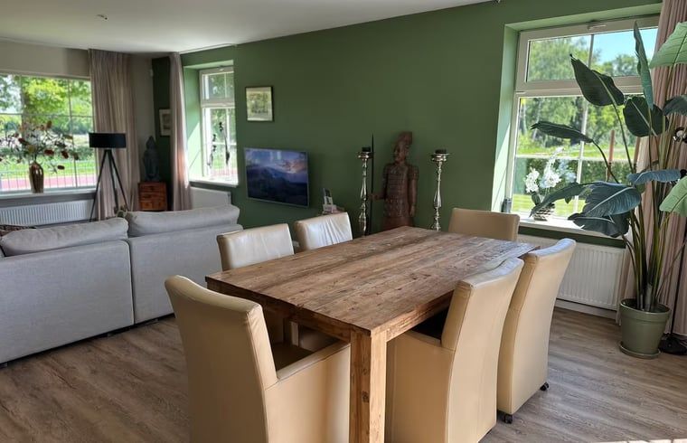 Dining room with wooden table in Holiday home in Enschede, ideal for family.