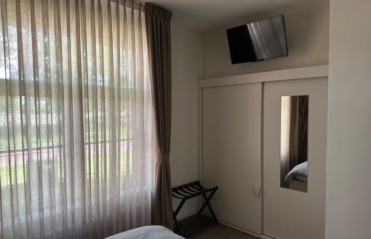 Bedroom with television in Holiday home in Enschede, ideal for relaxation.