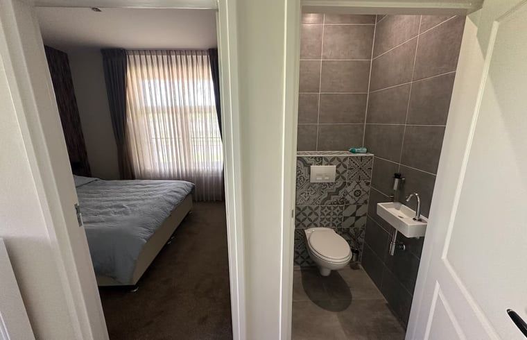 Bathroom and bedroom in Holiday home in Enschede, practical and stylish.