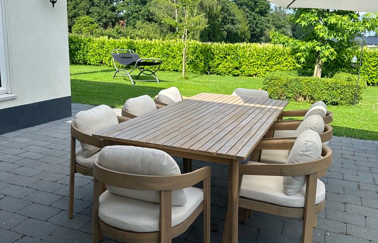 Terrace with wooden table in cottage in Enschede, ideal for outdoor dining.