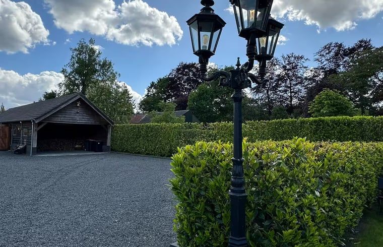 Spacious parking lot at Holiday home in Enschede, surrounded by greenery.