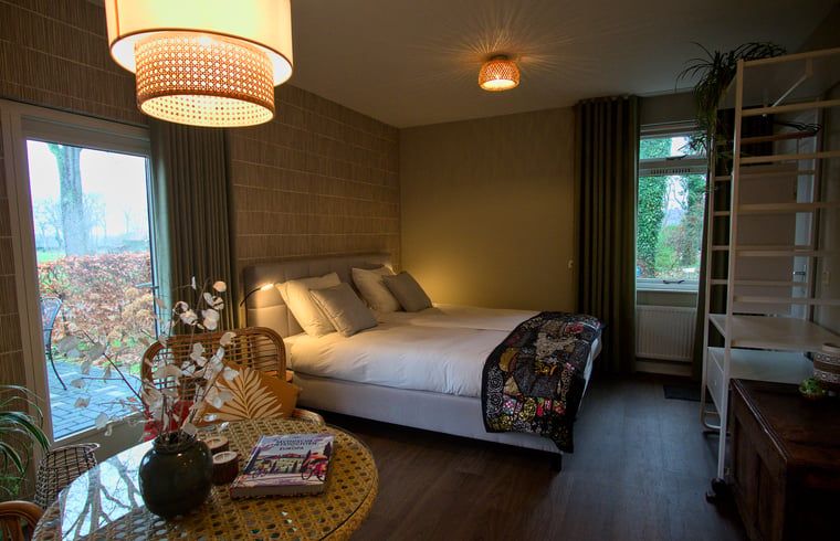 Gedetailleerd wandkleed in Vakantiehuis in Oldenzaal, Twente, voegt een artistieke touch toe aan de slaapkamer.