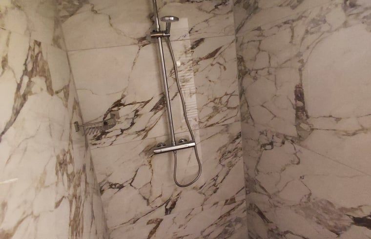 Stilvolle Dusche in einem Ferienhaus in Oldenzaal, Twente, mit Marmorfliesen und moderner Optik.