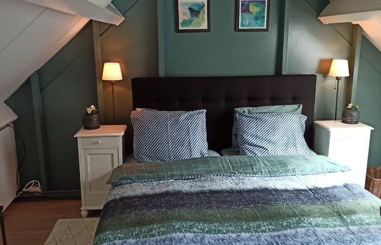 Gemuetliches Schlafzimmer im Ferienhaus in Oldenzaal, Twente, mit stimmungsvoller Beleuchtung.