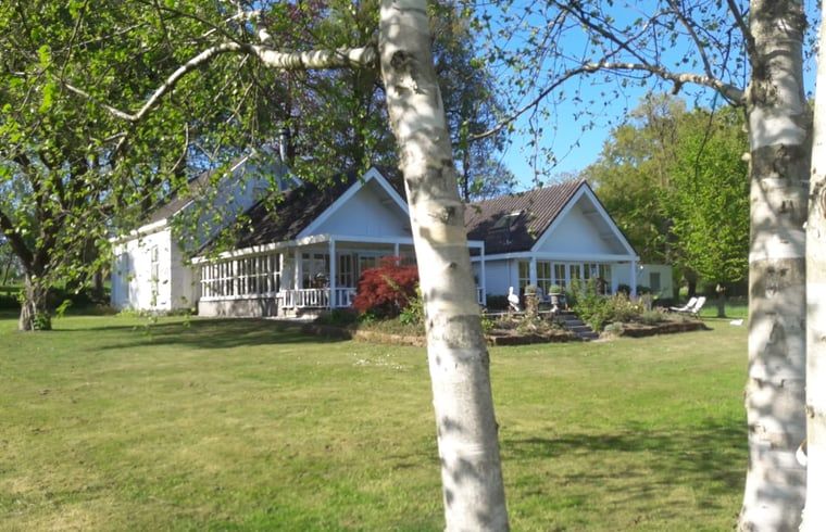 Cottage in Oldenzaal, Ferienhaus in Twente, umgeben von gruenen Baeumen und Ruhe.