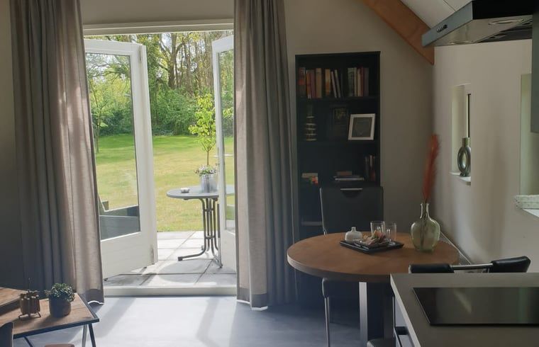 Gezellige binnenruimte van Huisje in Westerhaar-Vriezenveensewijk, Twente, met uitzicht op groene tuin.