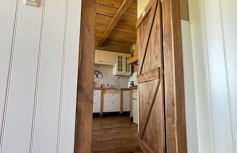 Gemuetlicher Innenbereich des Ferienhauses in Markelo, Twente, mit Blick auf die gruene Landschaft von Overijssel.