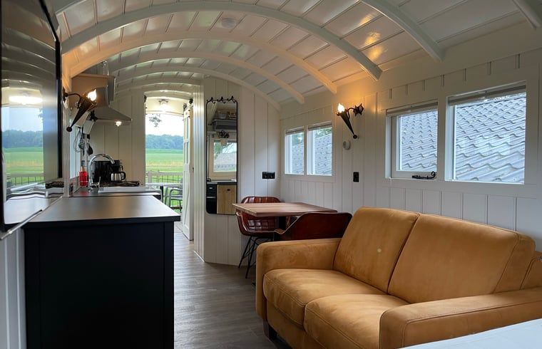 Gezellige woonkamer in Vakantiehuisje in Markelo, Twente, Overijssel met comfortabele bank en eethoek.