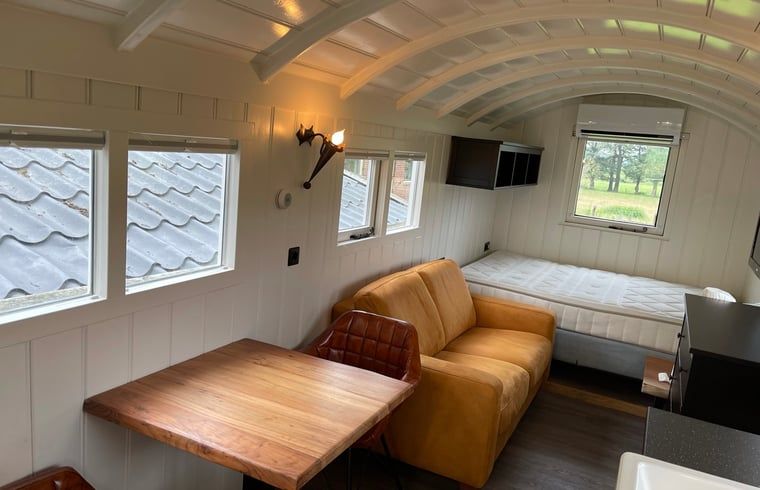 Rustieke eethoek in Vakantiehuisje in Markelo, Twente, Overijssel met uitzicht op de groene omgeving.