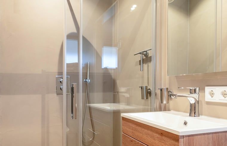 Sfeervolle bakstenen muur in Vakantiehuis in Usselo, Twente, met moderne verlichting voor een warme ambiance.