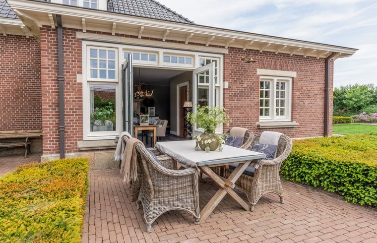 Sonnige Terrasse mit Sitzgelegenheiten im Ferienhaus in Denekamp, ideal fuer Mahlzeiten im Freien in Twente, Overijssel.