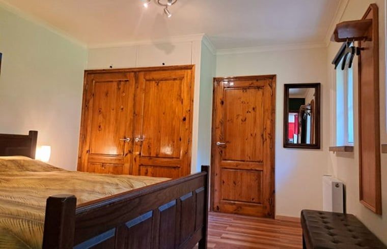 Cottage in Denekamp, vacation home in Twente, Overijssel, bedroom with wooden cabinets and doors.