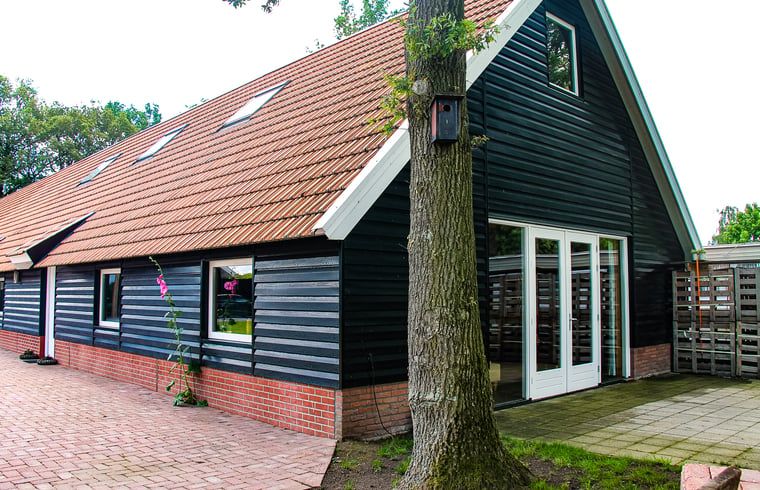 Charming cottage in Denekamp, Twente, with wooden facade and red roof tiles. Perfect vacation home in Overijssel.