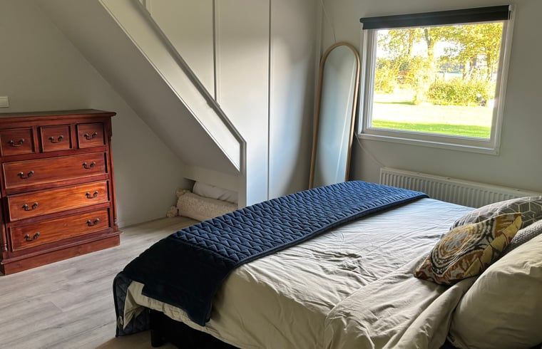 Bedroom with wooden furniture in vacation home in Denekamp, Twente. Enjoy peace and quiet in this vacation home in Overijssel.