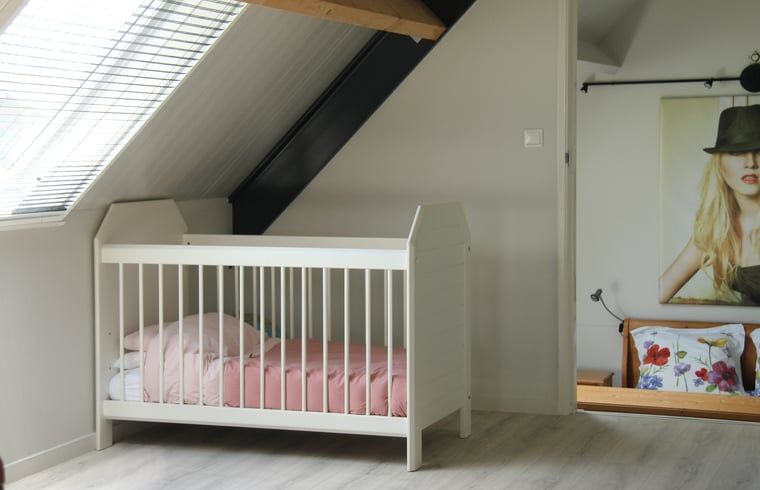 Crib in attic room of vacation home in Denekamp, Twente. Family-friendly vacation home in Overijssel.