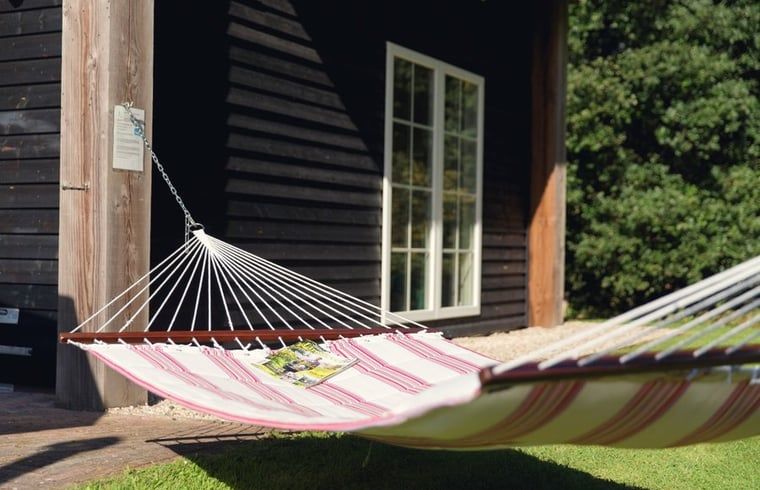 Relaxen in een hangmat bij Huisje in Notter, vakantiehuis in de groene omgeving van Twente, Overijssel.