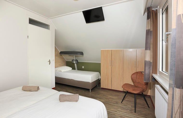 Geraeumiges Schlafzimmer mit Zusatzbett in einem Ferienhaus in Deurningen, ideal fuer Familien in Twente, Overijssel.