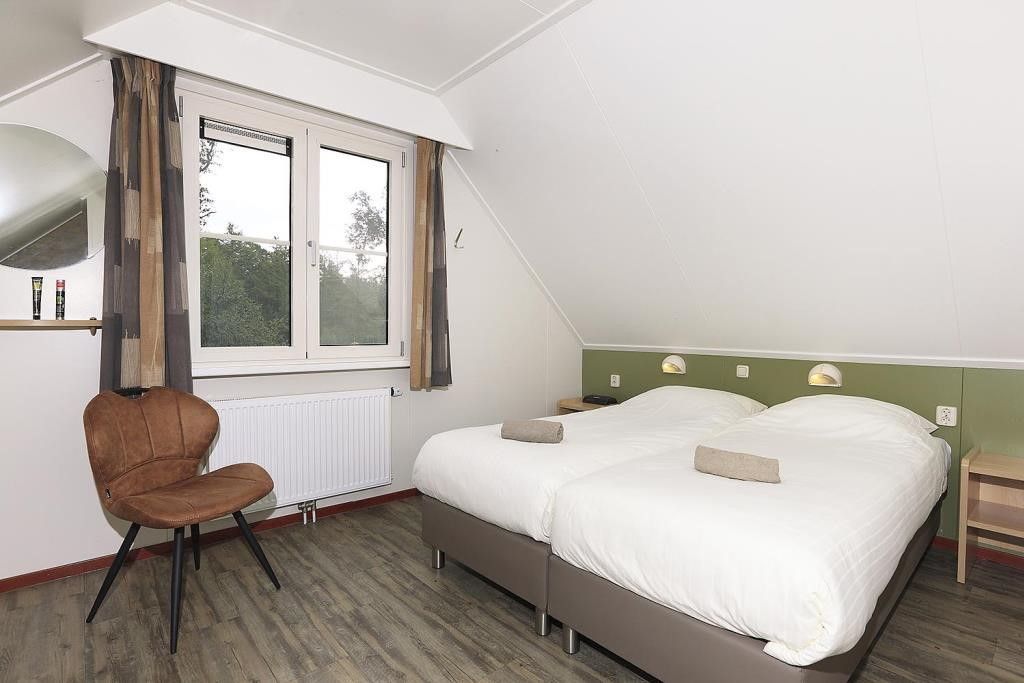 Comfortable bedroom in Boshuus Comfort Plus vacation home in Deurningen, Twente, overlooking the natural surroundings.