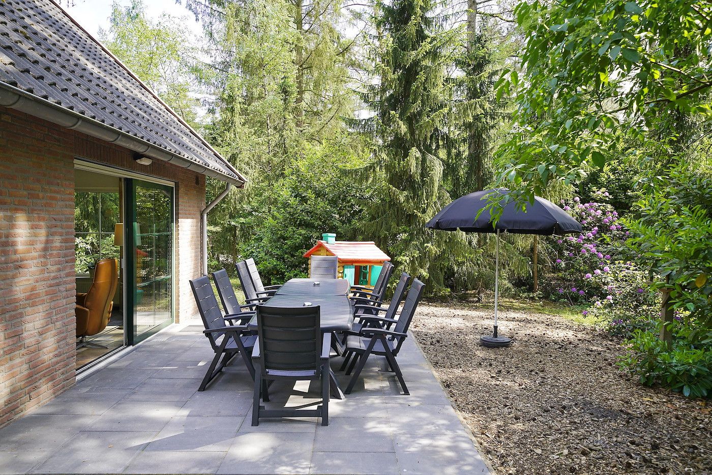 Terrasse mit Gartenmoebeln im Family House in Deurningen, umgeben von Natur.