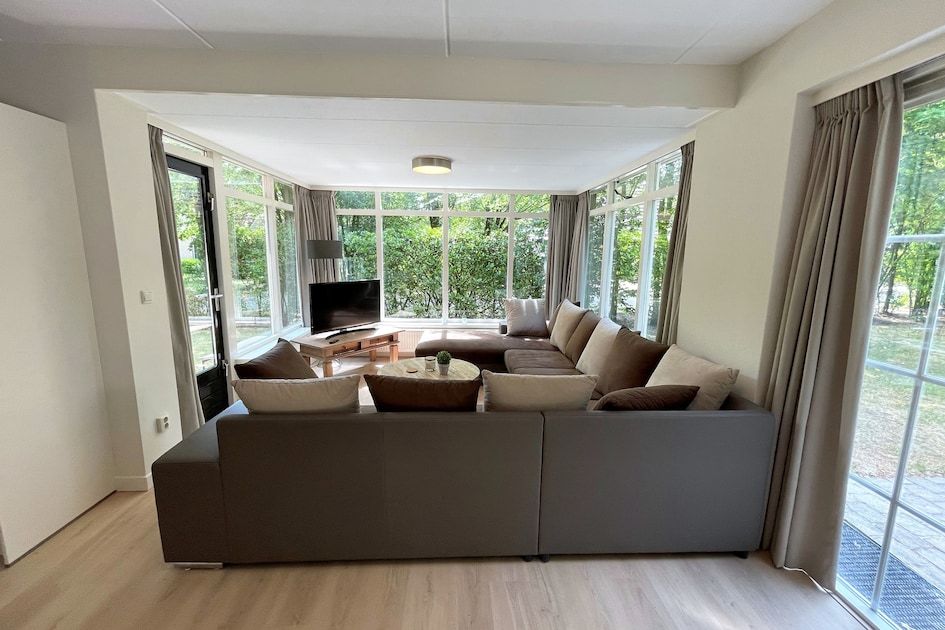 Gezellige woonkamer in bungalow Vuurvlinder met Serre 10, Hoge Hexel, Twente. Ruime zithoek met uitzicht op de groene natuur van Overijssel.