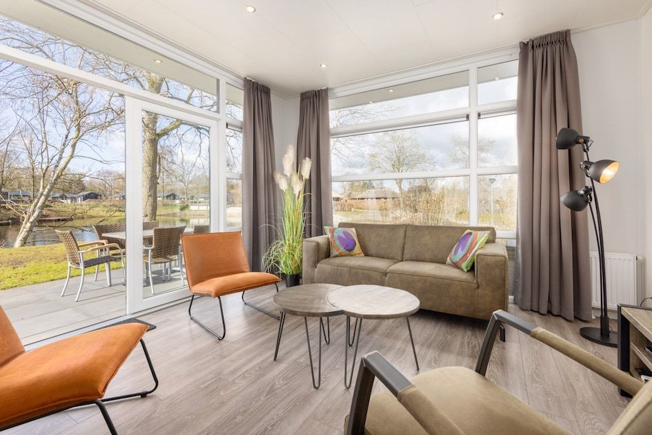 Stylish living room of vacation home Regge 6 in Hoge Hexel, Twente. Enjoy the view of the green surroundings and the inviting terrace.