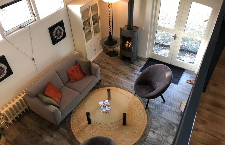 Lichte woonkamer met open haard in vakantiehuis in Vroomshoop, Twente.