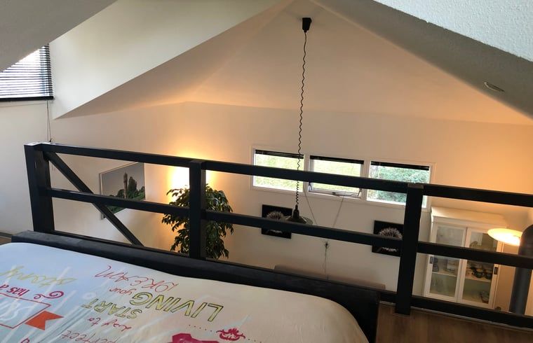 Knusse slaapkamer met groot raam in vakantiehuis in Vroomshoop, Twente.