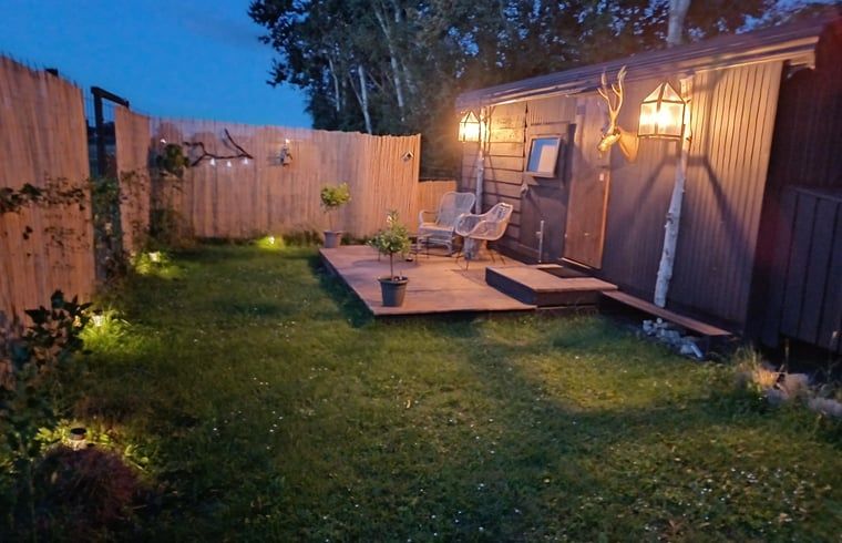 Verlichte tuin bij nacht bij Huisje in Vroomshoop, vakantiehuis in Twente, Overijssel.