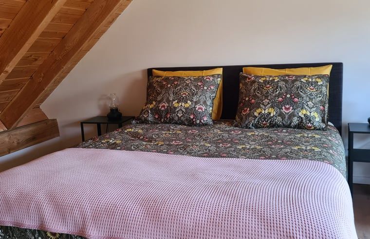 Comfortabele slaapkamer in Vakantiehuisje in Hengevelde, Twente met kleurrijk beddengoed.