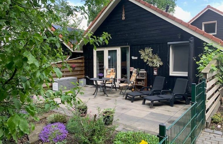Geniessen Sie die sonnige Veranda des Ferienhauses in Boekelo, Twente, ideal zum Entspannen in der Natur.
