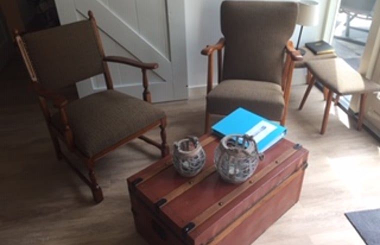 Gemuetliche Sitzecke im Ferienhaus in Boekelo, Overijssel, mit bequemen Sesseln und einer rustikalen Atmosphaere.