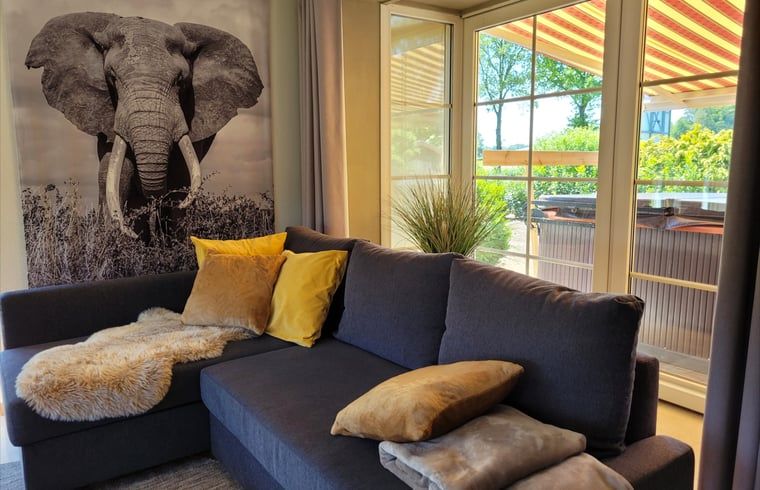 Gemuetliche Sitzecke im Ferienhaus in Lonneker, Twente, mit Blick auf die Terrasse und die Natur von Overijssel.