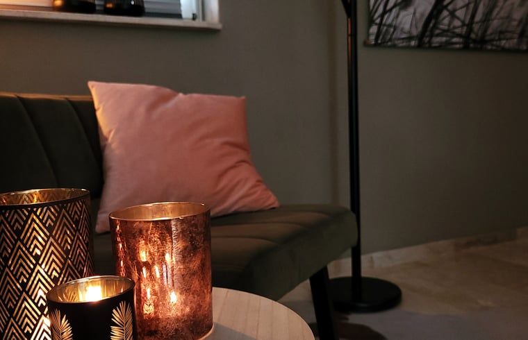 Stimmungsvolle Kerzen im Wohnzimmer des Ferienhauses in Lonneker, Twente, fuer ein warmes Ambiente in Overijssel.