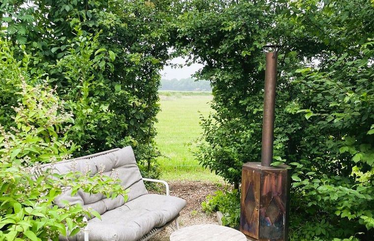 Knusse zithoek in de tuin van Vakantiehuisje in Bornerbroek, Twente, Overijssel met uitzicht op de natuur.